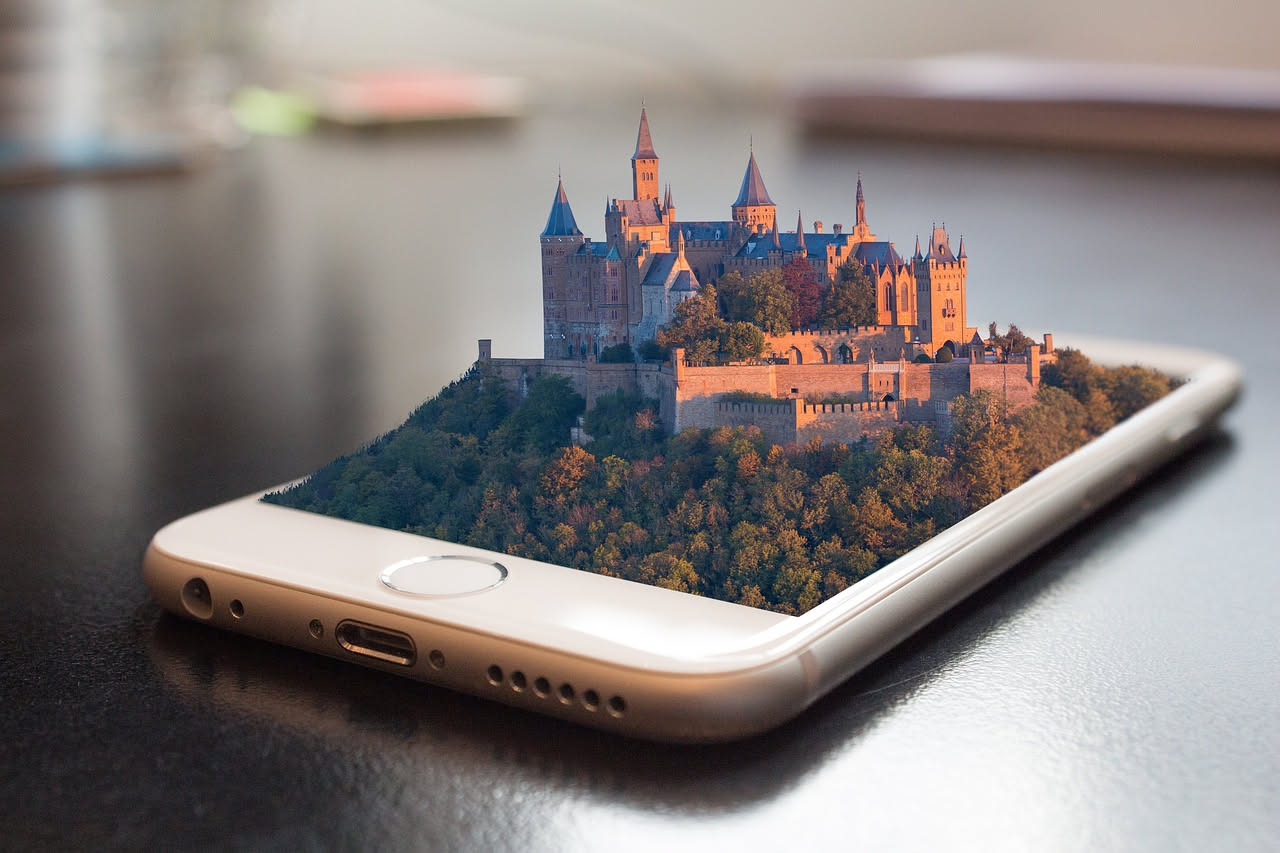 Schermo di smartphone che mostra un mobile di colore grigio sovrapposto a un ambiente domestico reale, con muri bianchi e finestra sullo sfondo