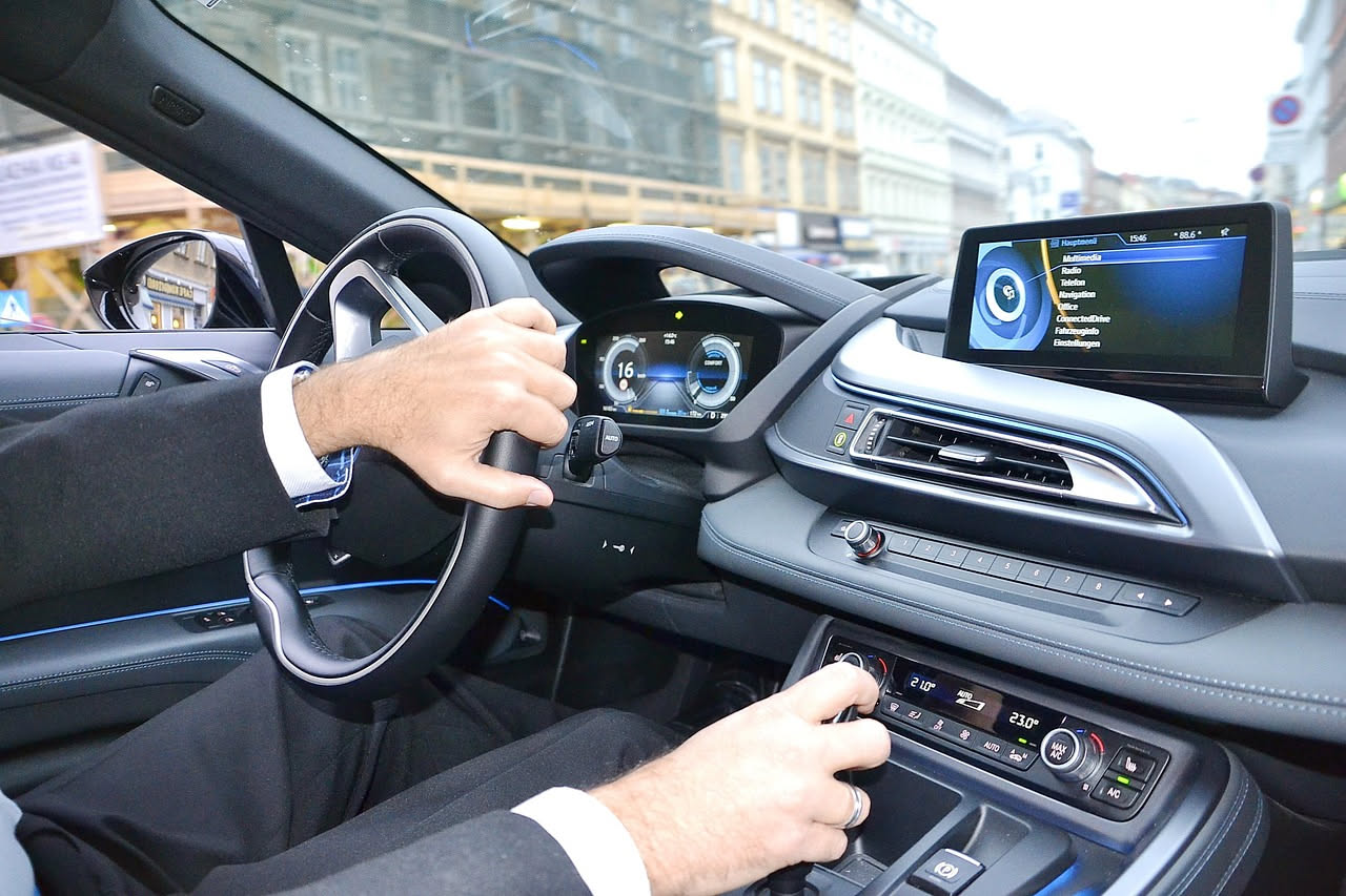 Automobile con sensori, telecamere e antenna sul tetto, con grafica che mostra i dati elaborati in tempo reale e la rilevazione degli ostacoli sulla strada