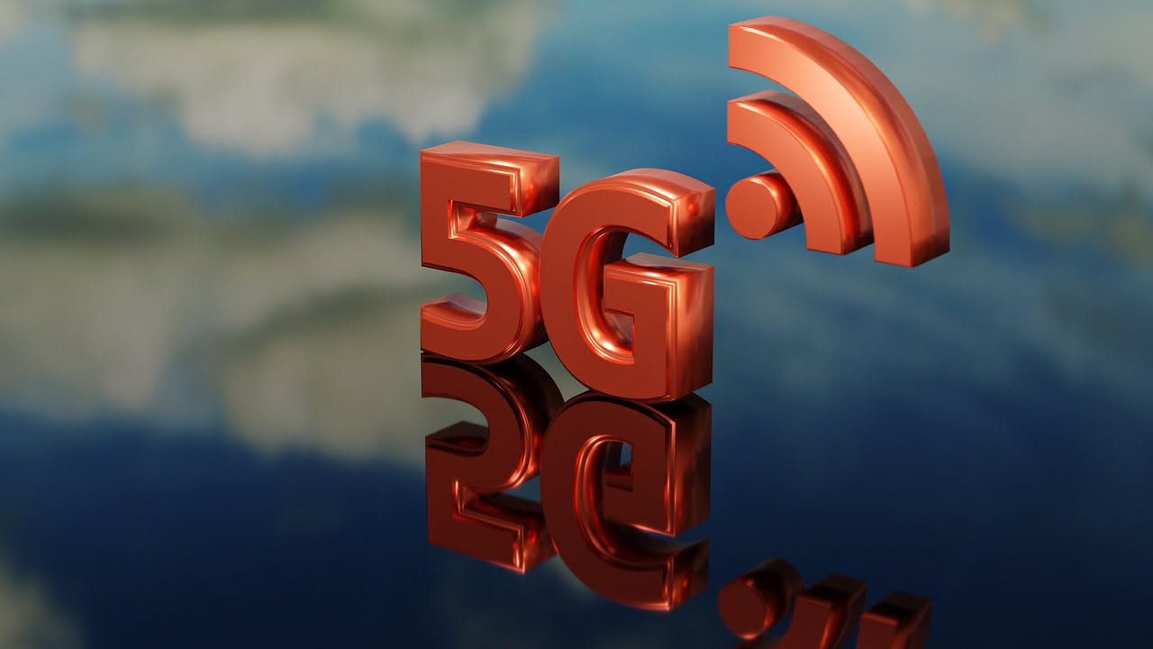 Torre di trasmissione 5G con antenne multiple su uno sfondo di cielo azzurro, circondata da onde radio blu che si propagano nello spazio