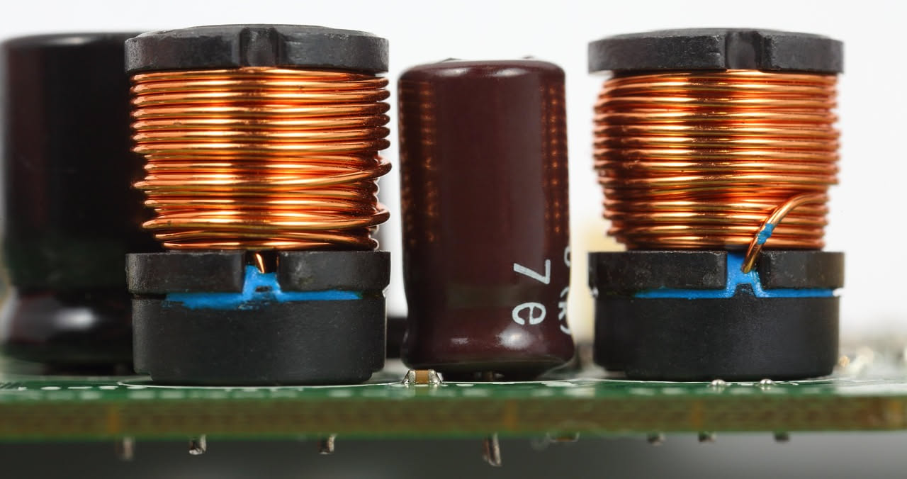 Smartphone bianco appoggiato su un caricabatterie wireless circolare nero, con simbolo di onde magnetiche stilizzate intorno al dispositivo