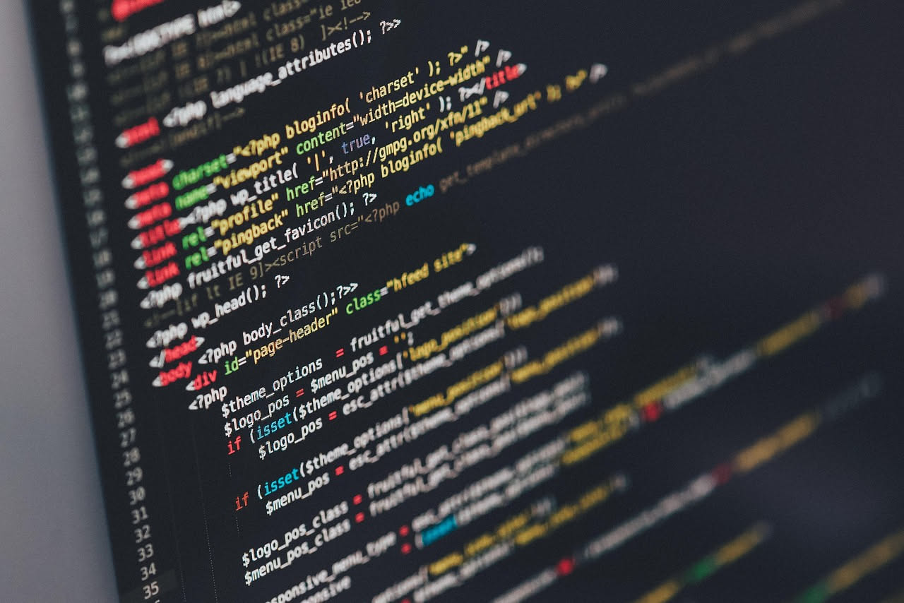 Schermo di computer con codice binario verde su sfondo nero, linee di dati che si muovono, lucchetto digitale in primo piano con simbolo di avvertimento