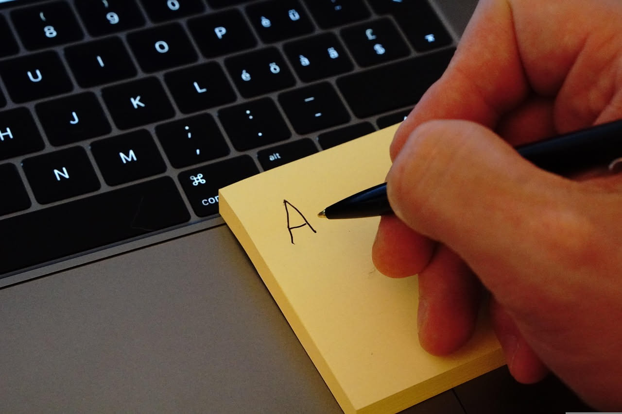 Una persona scrive al computer con sullo schermo un elenco strutturato e organizzato, con titoli, sottotitoli e punti elenco ben definiti in diversi colori